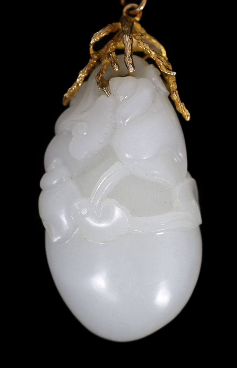 A Chinese white jade ‘conch shell’ yellow metal mounted pendant